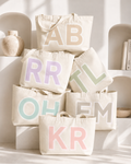 Personalised oversized tote bags stacked in pastel colours with custom shadow font initials – House of Her OMG Bag
